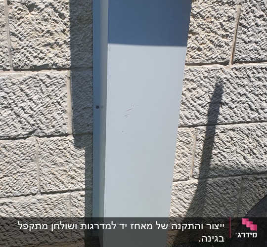 ארון חשמל אפור מותקן על קיר אבן חיצוני